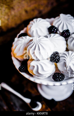 Cookies meringue witj mûres sur fond rustique Banque D'Images