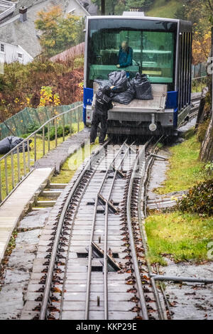 Bergen, Norvège - Octobre 2017 : homme noir de déchargement de sacs remplis de produits d'entretien du funiculaire Floibanen en direction de la station finale Banque D'Images