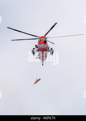 Searcg norvégien et de sauvetage par hélicoptère effectuant un exercice de sauvetage en mer. Banque D'Images