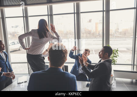 Heureux les jeunes et businesswomans businessmans faisant office de haut en cinq Banque D'Images