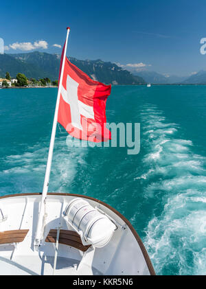 Drapeau arrière soufflant avec croix suisse sur le bateau dans le lac de Genève Banque D'Images