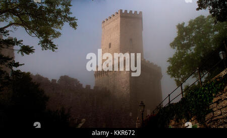 Italie, Sicile, province de Trapani, Erice, château normand, castello tu venere, tour, tôt le matin, brouillard, nuages, arbres, les lacunes Banque D'Images