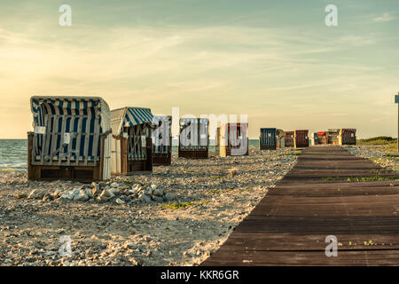 Wallnau, île de Fehmarn, Ostholstein, Schleswig-Holstein, Allemagne. Chaises de plage sur la plage de Wallnau dans la lumière du soir. Banque D'Images