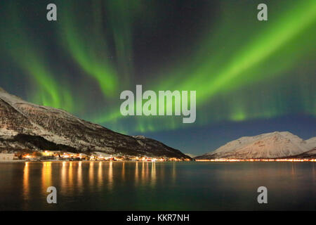 Les Aurores Boréales se reflète dans la mer glacée entouré par des sommets enneigés des Alpes de Lyngen Kafjord Manndalen Tromsø Norvège Europe Banque D'Images