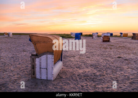 Des paniers de plage à la plage de carolinensiel, Frise orientale alors que le soleil se couche Banque D'Images