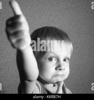 4-year-old woman avec thumb up s'appuie fanny face Banque D'Images