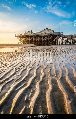 Sankt Peter-Ording, Eiderstedt, Frise du Nord, Schleswig-Holstein, Allemagne. Maison de pilotis sur la mer de Wadden à marée basse. Banque D'Images