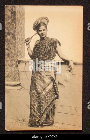 Cette photographie historique montre une dame tamoule du Sri Lanka dans les années 1910, tenant un éventail de main. L'image reflète la tenue vestimentaire culturelle et le mode de vie des femmes sri-lankaises au début du XXe siècle. Banque D'Images