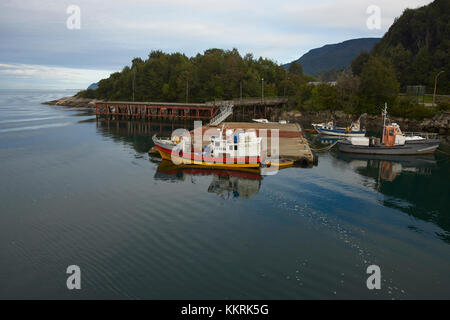 Bateaux de pêche sur la côte dans la petite ville de Chaiten sur la Carretera Austral dans le sud du Chili. Banque D'Images