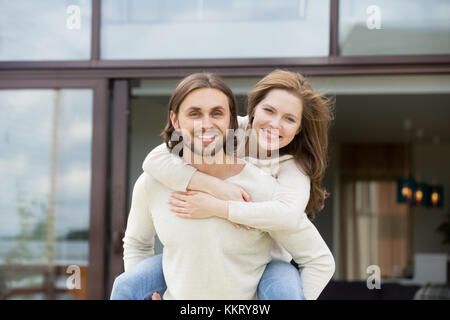 Man holding woman on retour à l'extérieur, looking at camera, portrait Banque D'Images