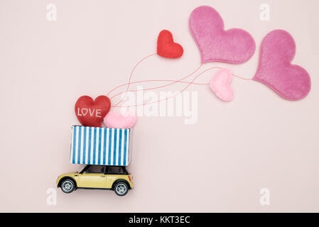 Toy voiture transportant heart-shape balloon, concept de la Saint-Valentin, la sélection du point af. Banque D'Images