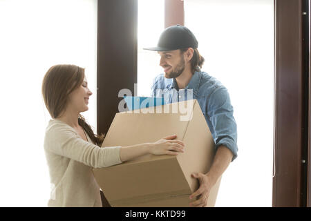 Le concept de service de livraison, femme qui reçoit fort de courier à ho Banque D'Images