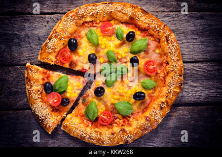 Pizza végétarienne avec du fromage et des légumes ci-dessus sur la table en bois Banque D'Images