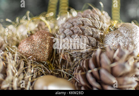 Colorful golden décorations de Noël d'un panier en bois avec des pommes de pin fait avec effet granuleux désaturées. L'extrême profondeur de champ et la couleur