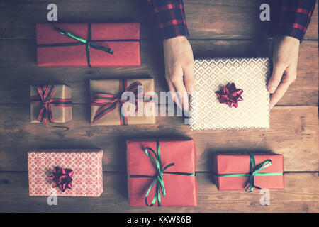 Woman's hands holding paniers-cadeaux sur la vieille table en bois. Vue de dessus Banque D'Images