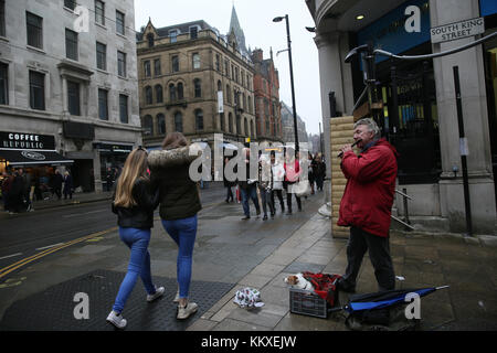 Manchester, UK. 2 Décembre, 2017. Un homme jouant d'une flûte que son chien se trouve dans une caisse dans les rues de la Ville Centre, Manchester,2 Décembre, 2017 Crédit : Barbara Cook/Alamy Live News Banque D'Images