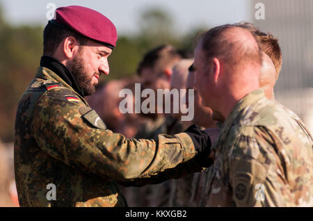 Fort Bragg, Caroline du Nord, États-Unis. 1er décembre 2017. Dec. 1, 2017 - FORT BRAGG, N.C., États-Unis - L'armée allemande Lt. Col. Tomas Tintor, présente les ailes de saut de sa nation aux parachutistes de l'armée américaine après avoir réussi un saut sur Sicily Drop zone, vendredi, lors de la 20e opération annuelle Randy Oler Memorial Toy Drop. L'opération aéroportée, hébergée par le Commandement des affaires civiles et psychologiques de l'armée américaine (Airborne), est la plus grande opération aéroportée combinée au monde avec des parachutistes de neuf Nations alliées. L'événement annuel permet aux parachutistes d'aider les enfants i. Banque D'Images