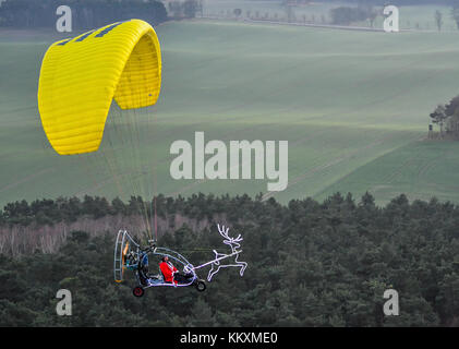 Un homme vêtu d'un costume de Père Noël volant sur un tricycle et un planeur à moteur au-dessus de la campagne près de Treplin, Allemagne, le 2 décembre 2017. Photo : Patrick Pleul/dpa-Zentralbild/dpa Banque D'Images