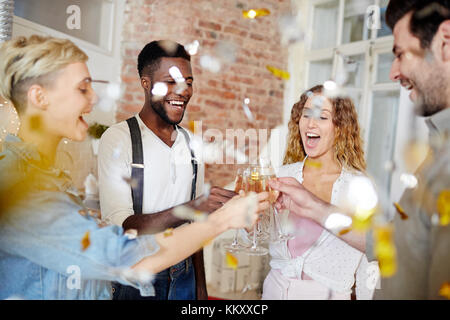 Les filles de joie et leurs petits amis de trinquer avec des flûtes à champagne confetti en automne Banque D'Images