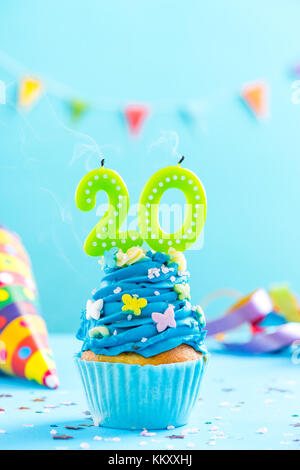 20e 20e anniversaire cupcake bougie avec blow up et paillettes. maquette de la carte. Banque D'Images