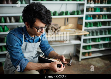 Martelage cordonnier professionnel ongles dans ses chaussures en cuir par unique Banque D'Images