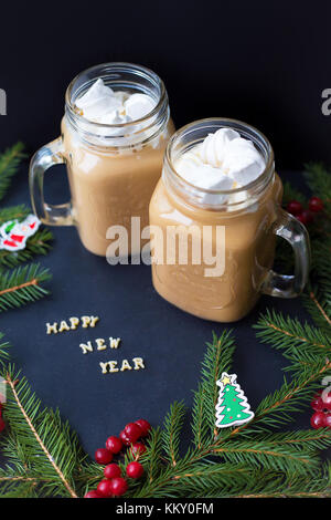 Marshmellou le cacao, l'arbre de Noël avec des décorations sur un fond noir. l'inscription Bonne année Banque D'Images