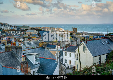 Une longue distance sur les toits de la ville de St Ives, Cornwall. Donnant sur la mer bleue avec les bâtiments du port baigné de soleil en fin d'après-midi Banque D'Images