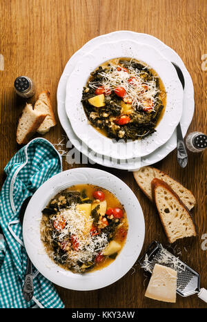 Chou frisé (ou cavolo nero) et d'orge d'hiver. soupe soupe de légumes sur une table en bois et du pain frais Banque D'Images