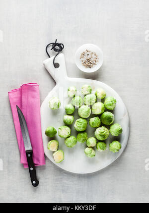 Chou de Bruxelles sur une planche à découper en marbre blanc et couteau. Épices et ingrédients alimentaires. la cuisson des aliments sains Banque D'Images