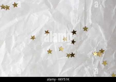 Décoration, Contexte, concept texturés. or petites étoiles brillent sur le fond de papier froissé à l'emballage des cadeaux pour maison de vacances Banque D'Images