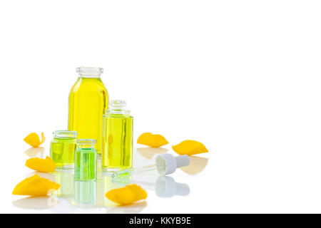 Une bouteille d'huile essentielle de rose avec pétales de roses jaunes sur whitebackground Banque D'Images