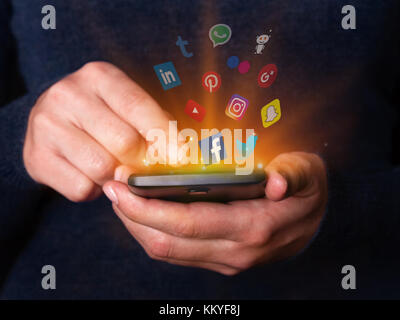 Femme mains tenant à l'aide de leurs mobiles smartphone réseau social media Facebook Twitter YouTube apps snapchat Instagram pinterest google plus Banque D'Images