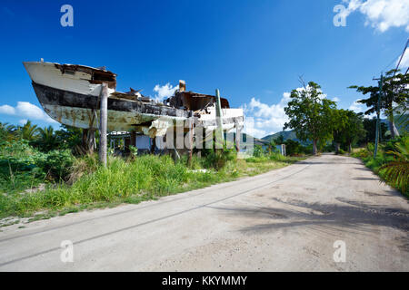 Une vieille épave combinée avec un bâtiment sur le côté de la route à Antigua. Banque D'Images