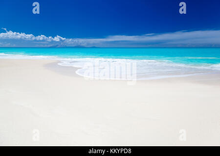 Un blanc pur caraïbes beach avec ciel bleu profond et turquoise de l'eau. l'île de Montserrat à l'horizon. Banque D'Images