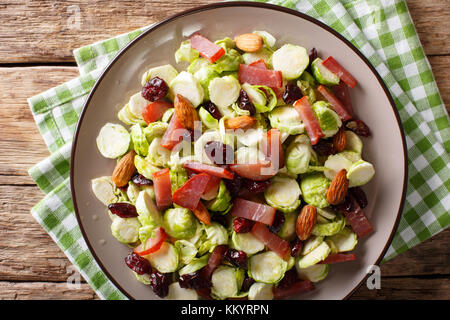 Salade maison de tranches de choux de Bruxelles, les canneberges, Amandes et de jambon sur une plaque sur une table horizontale. haut Vue de dessus Banque D'Images