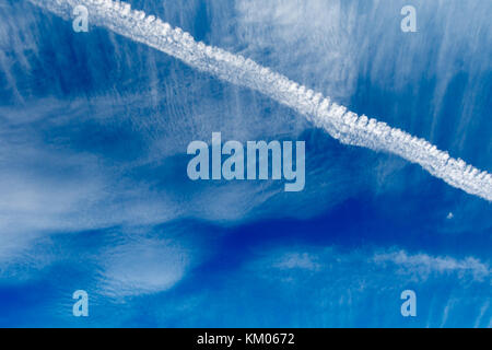 Trace d'avion traverse un ciel nuageux. Banque D'Images