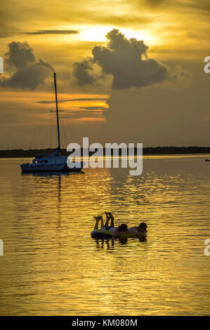 Coucher du soleil coucher du soleil à keywest key west florida usa avec voile et flottant silhouette personnes heure d'or Banque D'Images