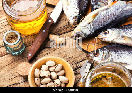 Verre de bière, poisson salé et les écrous sur la table en bois Banque D'Images