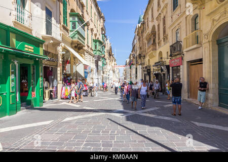 Les touristes se promener le long de l'Triq II Merkanti, rue piétonne à La Valette, Malte Banque D'Images