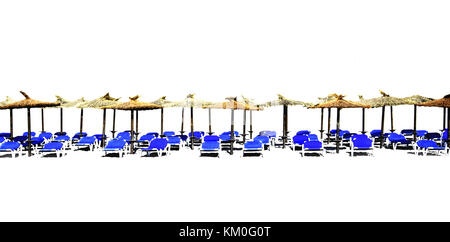 Plage des chaises longues avec parasols de paille dans une rangée isolé sur blanc pour la marge de conception Banque D'Images