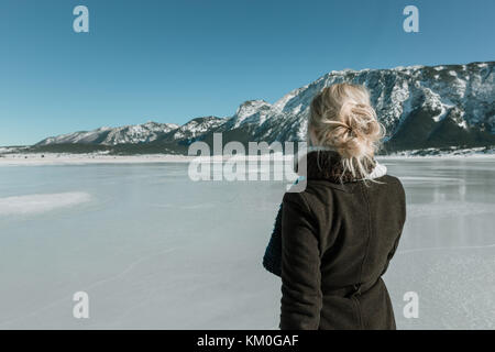 Vue arrière de la femme à la montagne et au lac gelé Banque D'Images