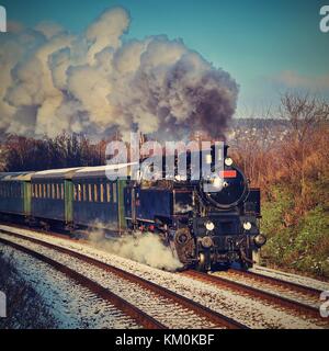 Beau vieux train à vapeur avec les chariots fonctionnant sur des rails au coucher du soleil. Des excursions pour les enfants et les parents sur les jours spéciaux de fête. République tchèque l'Europe. Banque D'Images