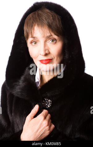 Femme mature portant des fourrures de vison avec capuche manteau isolé Banque D'Images