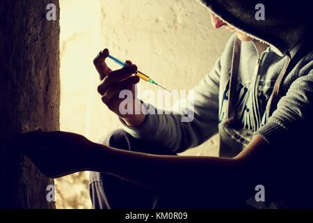 Concept de médicaments. concept de maladie. toxicomane homme avec l'aide de seringues médicaments.thème sombre, jeune homme très stressé, il aurait la toxicomanie. Banque D'Images