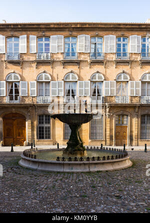 Une vieille fontaine dans une cour pavée, avec un immeuble de trois étages en stuc avec volets roulants, portes et fenêtres en bois sculpté avec whit Banque D'Images