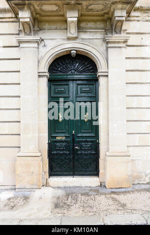 Porte en bois maltais avec de la peinture fraîche et portes de meubles en laiton poli. Banque D'Images