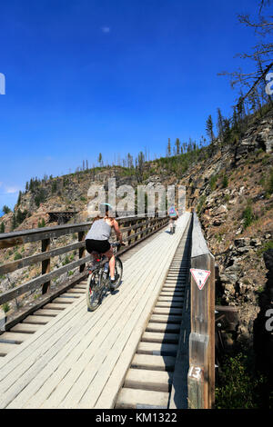 Les cyclistes le long de la piste cyclable, chevalets en bois du canyon Myra Myra Canyon, Ville, région de l'Okanagan, Kelowna, Colombie-Britannique, Canada. Banque D'Images