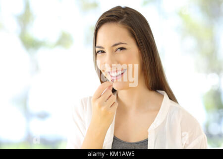 Portrait d'un smiley femme à prendre une pilule qui vous regarde Banque D'Images