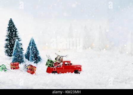 Années 1950 vintage antique camion rouge cadeaux de Noël une maison par l'intermédiaire d'un hiver enneigé wonder land de pins. L'extrême profondeur de champ wit Banque D'Images