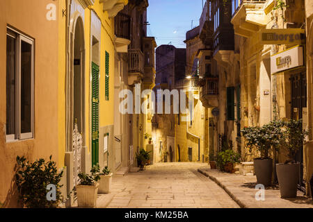 La nuit tombe sur une rue étroite de Vittoriosa (Birgu), Malte. Banque D'Images